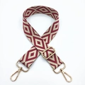Close-up of embroidered geometric diamond bag strap with light gold metal buckles - Burgundy