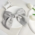 Close-up of silver-grey satin bow hair clip with elegant layered texture on white tray - Gray (Spring Clip)