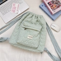 Quilted heart-patterned plaid drawstring backpack on desk with laptop and books - Cyan Yellow Plaid