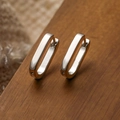 Minimalistische silberne ovale Creolen aus vergoldetem Kupfer auf einer Holzoberfläche - Oval / Silber (44282)