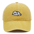 Close-up of cute white seal embroidery on a yellow washed cotton baseball cap texture - Yellow