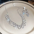 Gros plan d'un ensemble de bijoux nœud argenté étincelant avec strass sur un plateau - Ensemble Argent (2 pièces)