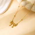 Collier nœud doré élégant avec perles sur présentoir en céramique minimaliste - Collier Mini Nœud Papillon