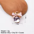 Detailansicht der rosa Emaille-Schleife und lila Kristallanhänger mit 1,4 cm Höhenmaß - Rosa