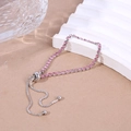 Détail d'un bracelet argenté ajustable orné de strass roses sur un support ondulé - Rose