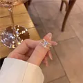 Gros plan d'une bague nœud dorée avec zircons pavés et double anneau portée à la main - Bague Nœud Papillon Micro-pavé en Zircone