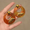Macro-opname van amberkleurige hars oorbellen met een gouden panterreliëf detail - 925 Sterling Zilveren Oorprikker Goud Bruin Luipaard Ring (1#)