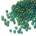 Close-up of 450g iridescent green glass seed beads scattered on a white background - Iridescent Army Green 167