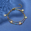 Detail of gold layered bracelet with star charms and colorful beads on blue velvet - Double Layer Star with Colorful Beads