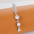 Silver navel ring with three vertical transparent zircons on orange leather background - Triple Drill Style (Silver White)