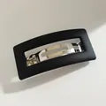 Minimalist matte black rectangular hair clip with cutout design and silver metal spring - Black
