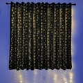 Detail showing warm white LED curtain string lights hanging on a black background - 3x2m Copper Wire Battery Box / Warm White