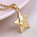Macro detail of a 18k gold plated stainless steel star pendant with a unique face design - Necklace / Gold