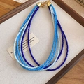 Detail of bohemian multi-layer beaded necklace with blue gradient beads and gold lobster clasp - Blue White Series