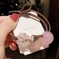 Détail de perles en cristal rose et breloques triangle doré sur un élastique à cheveux - Rose Pourpre