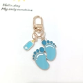 Detail of blue baby footprints and nursing bottle charms on a golden lobster clasp - Style A / Blue