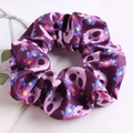 Detail of purple fabric scrunchie with pink skull and colorful floral print patterns - Purple Flower