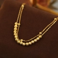Double-layer gold faceted bead bracelet on dark brown velvet background jewelry display - Gold