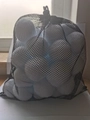 Detail of a black mesh storage bag filled with white snowballs for winter party play - 50pcs Mesh Bag 5cm / White