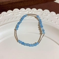 Elegant beaded bracelet with blue round stones and curved silver tubes on ceramic tray - 4# Bracelet - Silver and Blue