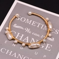 Gold wire-wrapped bracelet with natural white pearls on a minimalist grey display card - Gold White Long Pearl Style