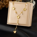 Detail of Y-shaped gold necklace with butterfly charms and pearls on a beige jewelry box - Butterfly Pearl Style (N3523)