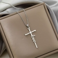 Macro detail of silver cross necklace featuring love script on an elegant jewelry box - LOVE / Steel