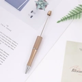 DIY beadable ballpoint pen in matte gold finish with a silver tip on a minimalist desk - Pearl Camel