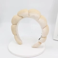 Detailed texture of braided velvet headband in cream white with a soft padded design - Beige
