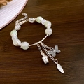 Bracelet en perles vert clair et blanc avec pendentifs papillon et fleur en argent - Style Plume Papillon Vert Argent