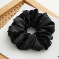 Dettaglio di un grande elastico in raso nero ad alta elasticità su sfondo bianco minimal - Raso Perlato Nero
