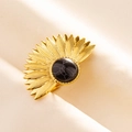 Nahaufnahme eines goldenen Sonnenblumenrings mit Marmorstein auf beigem Stoff - Gold Schwarz Stil (J545-G-B)