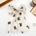 Detail einer großen cremefarbenen Organza-Haarspange mit schwarzen Schmetterlingsmustern - Schmetterlingsdruck
