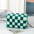 Dettaglio macro del astuccio a scacchi in peluche con texture morbida e zip verde - Quadri Verdi e Bianchi