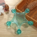 Handheld five-point star massager in translucent green plastic on a wooden background - Pentagram Massager Light Blue
