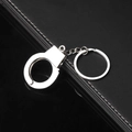 Nahaufnahme eines silbernen Handschellen-Schlüsselanhängers auf schwarzem Leder - Einzelne Handschelle / Silber
