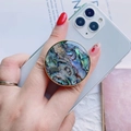 Collapsible shell texture phone socket with gold plated rim on a white smartphone - Gold Round Collapsible Socket Grip / Blue Abalone Shell