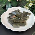 Macro view of rectangular labradorite stones with natural flash in a white ceramic dish - Labradorite