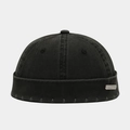 Detailed macro view of distressed edges and metal logo plate on black docker hat - Metal Label / Black