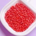 Macro shot of red peanut-shaped acrylic beads with pearl luster for DIY jewelry making - Red