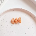 Détail d'une pince à cheveux en résine en forme de croissant sur une assiette décorative - Triple Croissant
