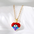 Detalle macro del collar de corazón dorado con esmalte colorido y amuleto de mal de ojo - Corazón Rojo