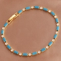 Detailed view of golden bracelet with blue rectangular gems on brown silk background - Peacock Blue Bracelet