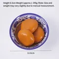Modelo de comida artificial realista con esferas de postre naranjas en un bol azul - Pastel de Arroz con Azúcar Moreno