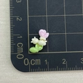 Macro shot of a 1cm mini resin flower accessory in pink, white, and green tones - Butterfly Bluebell