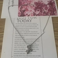 Detail of silver clover and ring pendant necklace on a decorative card background - Silver-Shell Clover Style