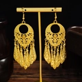 Detail of golden bohemian long tassel earrings featuring intricate hollow floral patterns - E5756-1 Layered Hollow Long Dangle