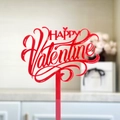 Macro shot of red acrylic Happy Valentine cake topper with elegant script font - Red Happy Valentine's Day