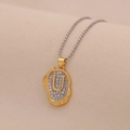 Macro shot of gold-tone pendant with clear crystals and letter U on silver ball chain - Letter U