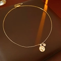 Dettaglio di una collana con pendente a stella dorata e zircone su pelle marrone scuro - Oro